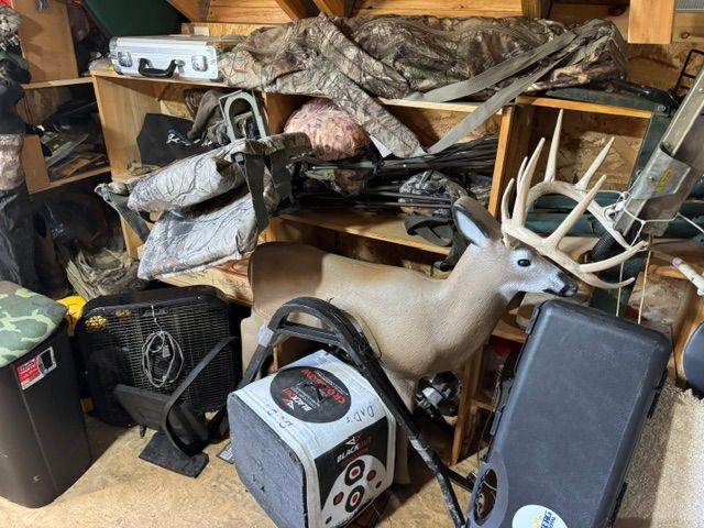 garage with stacked deer mounts and hunting supplies