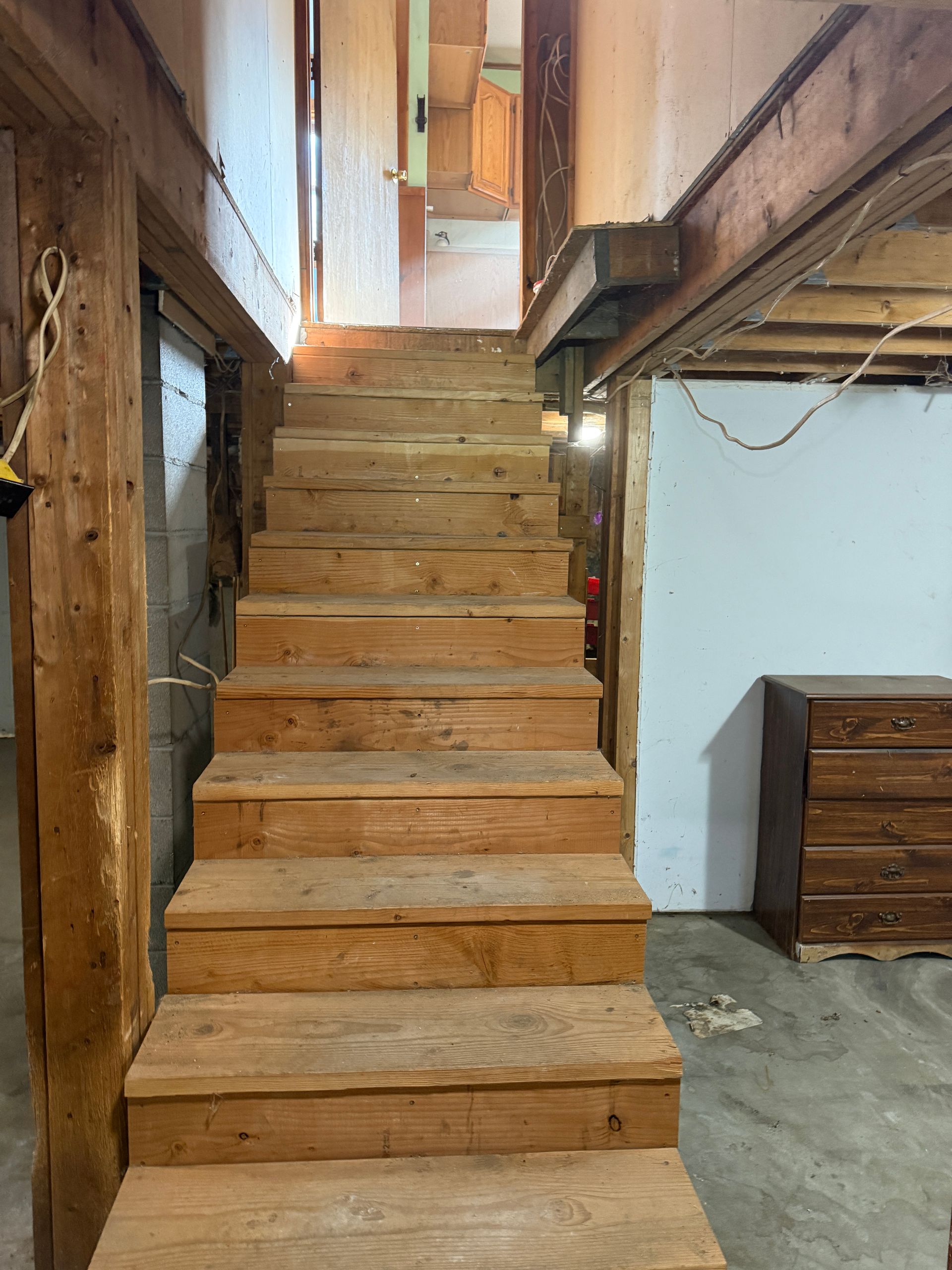 Steep wooden staircase in a narrow interior hallway