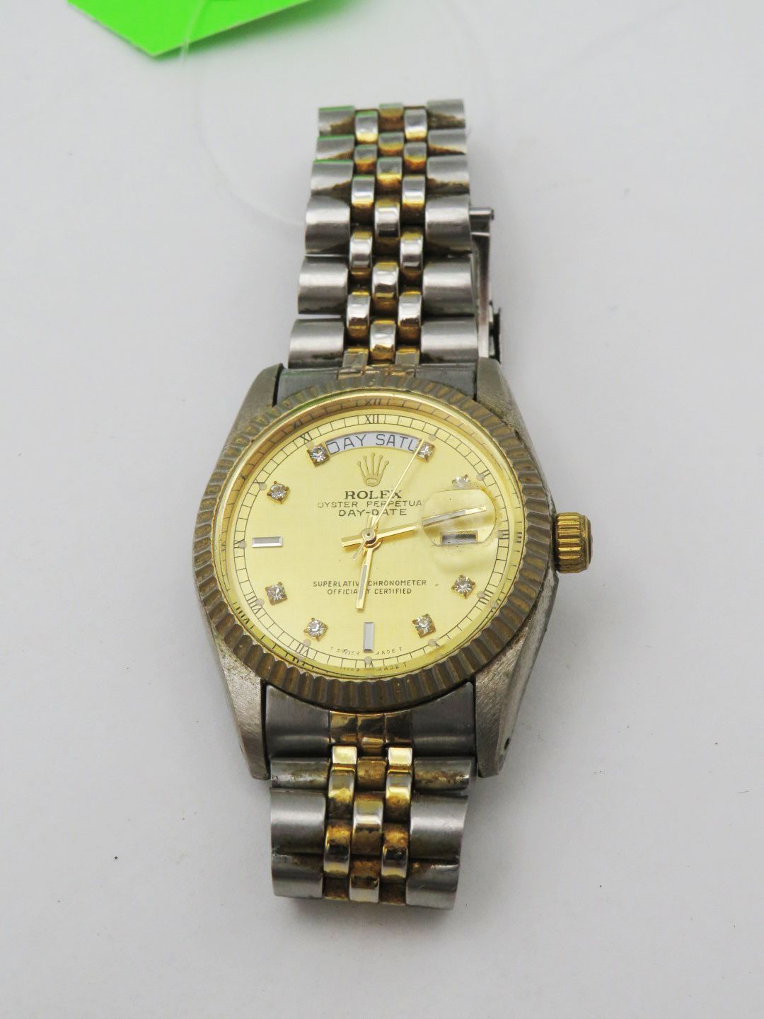 Two-tone Rolex watch with a gold-colored face, diamond hour markers, and a fluted bezel.
