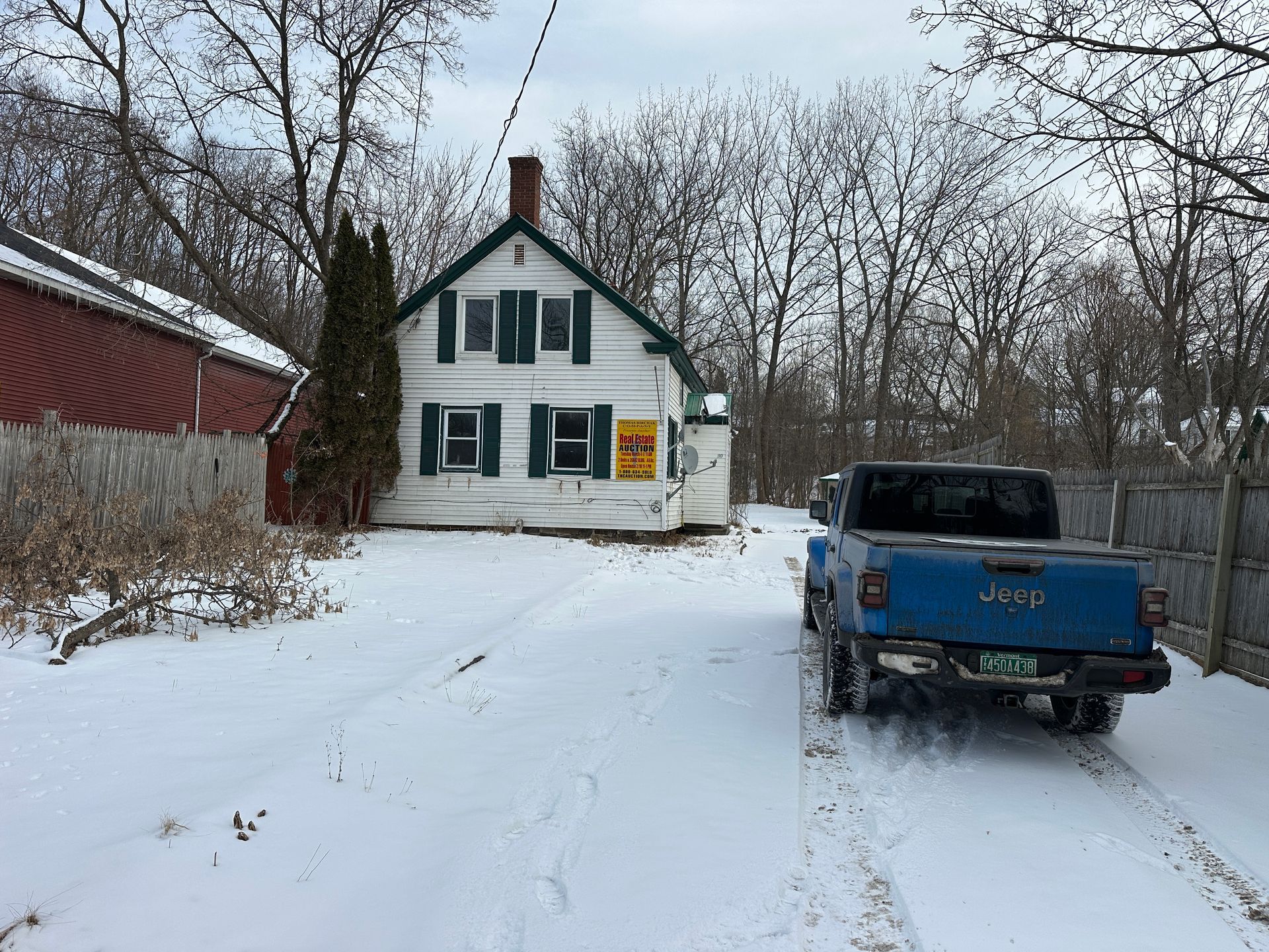 White house with green shutters and a red barn.