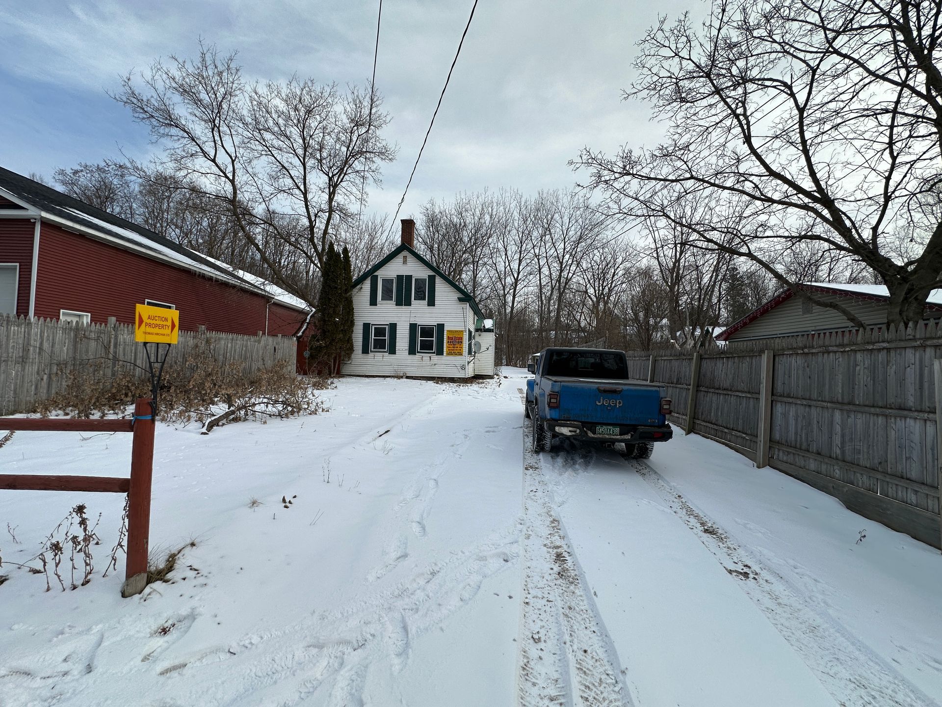 Snowy driveway leading to white house.