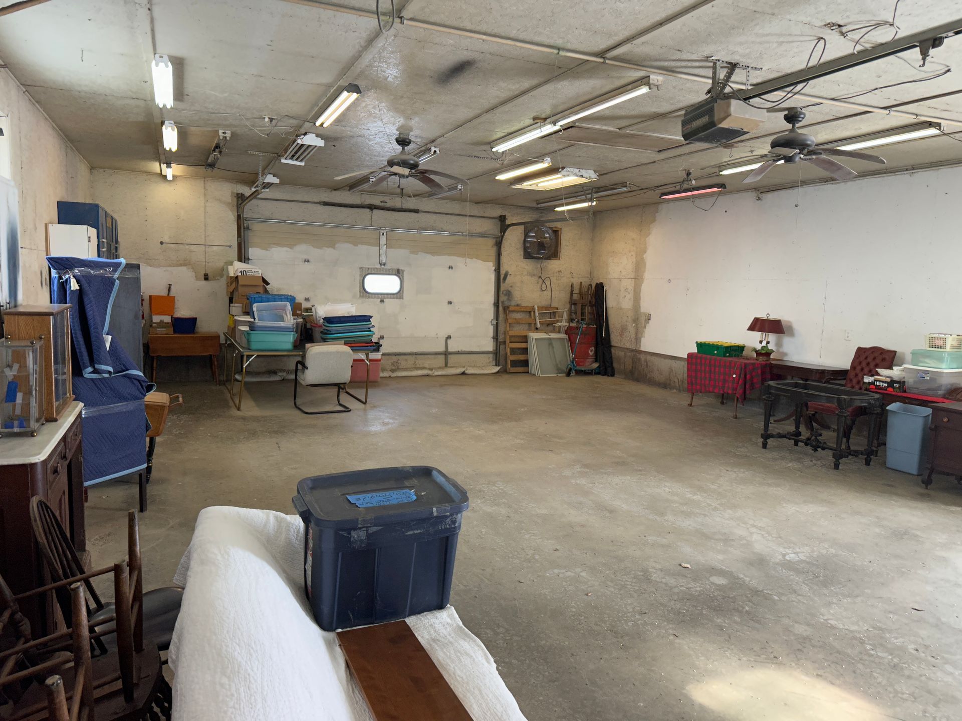 Garage interior with a car bay, and ceiling lights and fans.
