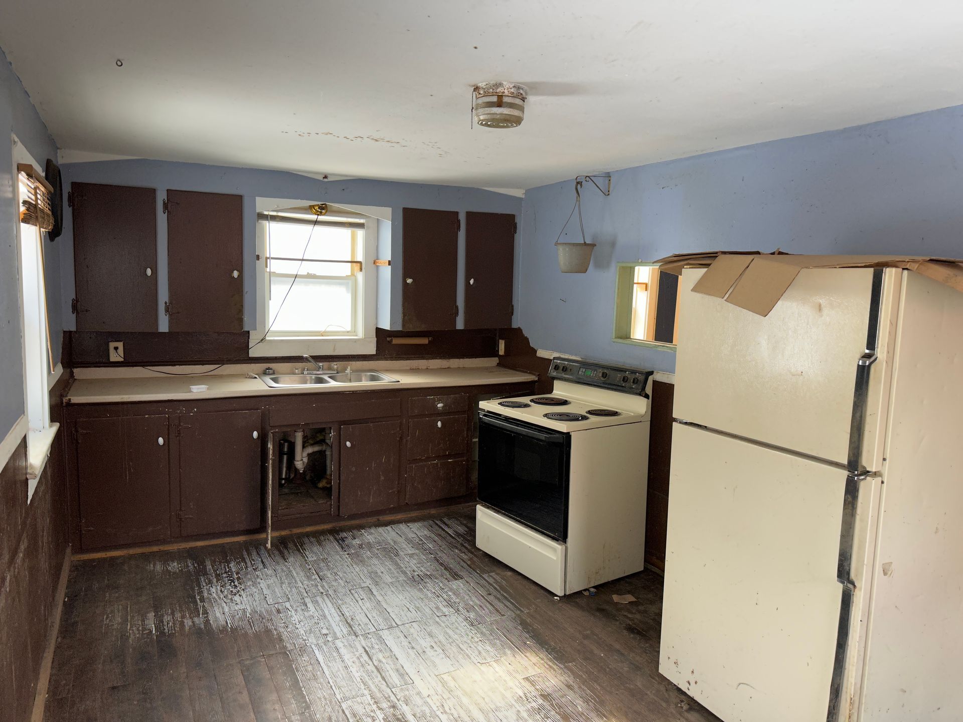 A kitchen with brown cabinets, white appliances.
