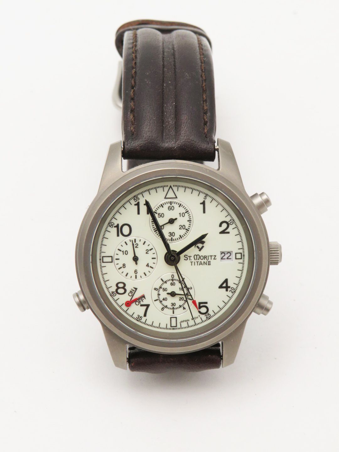 Titanium watch with a white face, black hands and numerals, and a brown leather strap.