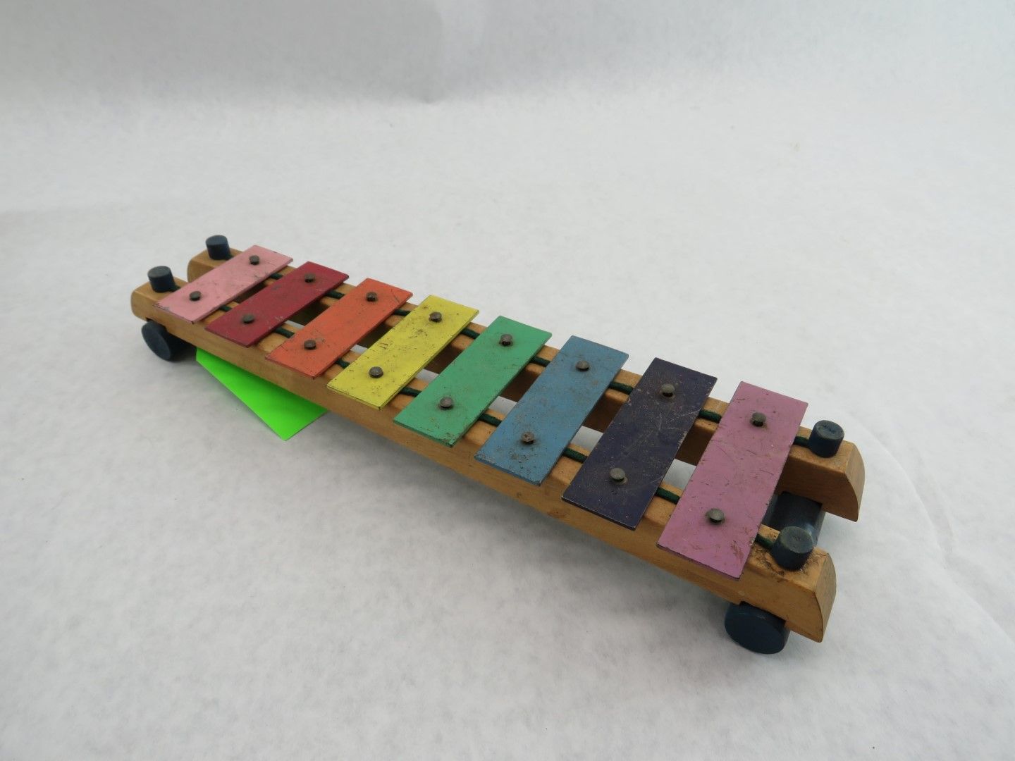 Colorful wooden xylophone toy with metal keys on a white surface. Antique.