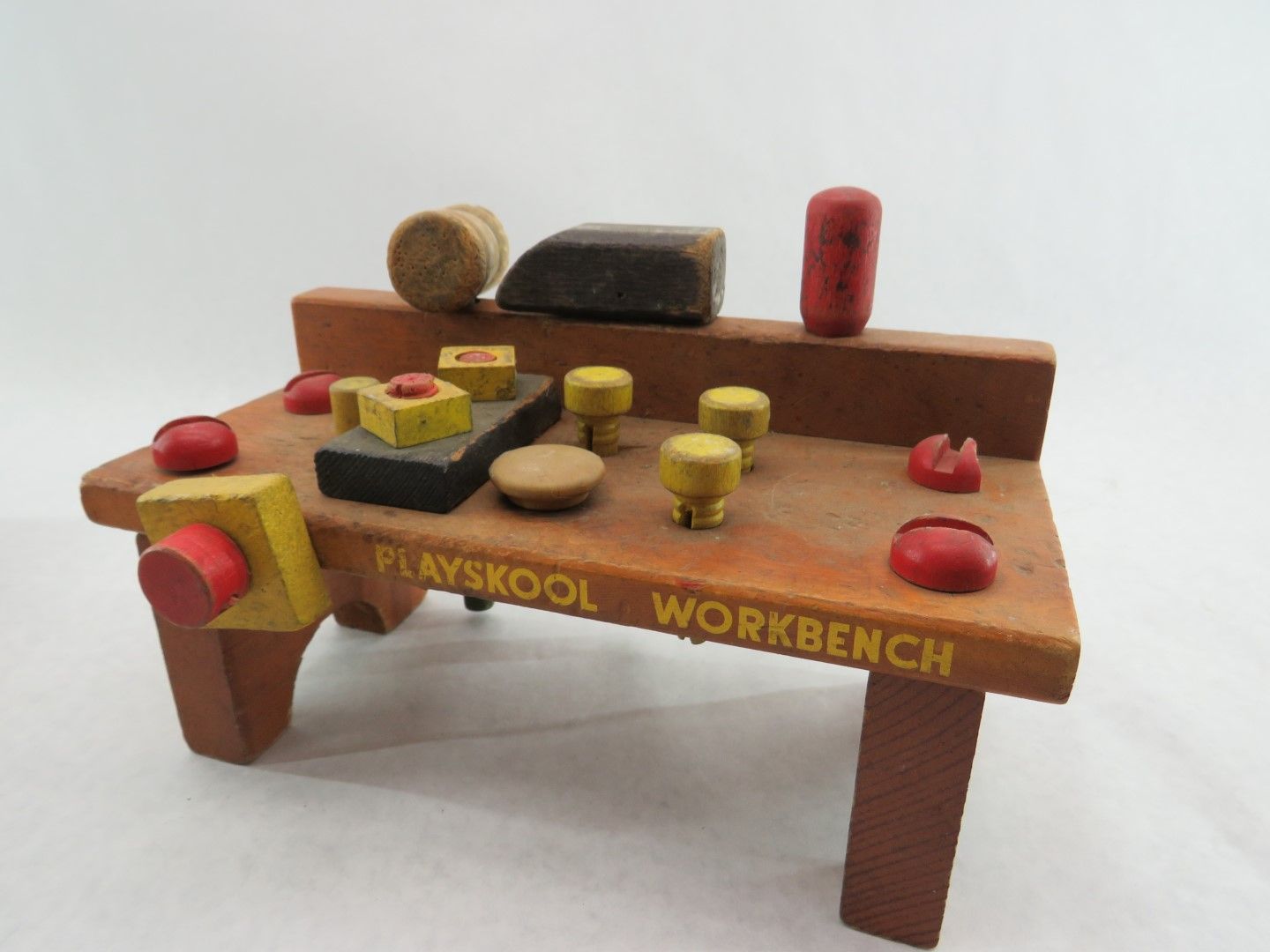 Wooden Playskool workbench toy with pegs, hammer, and blocks in various colors. Antique.