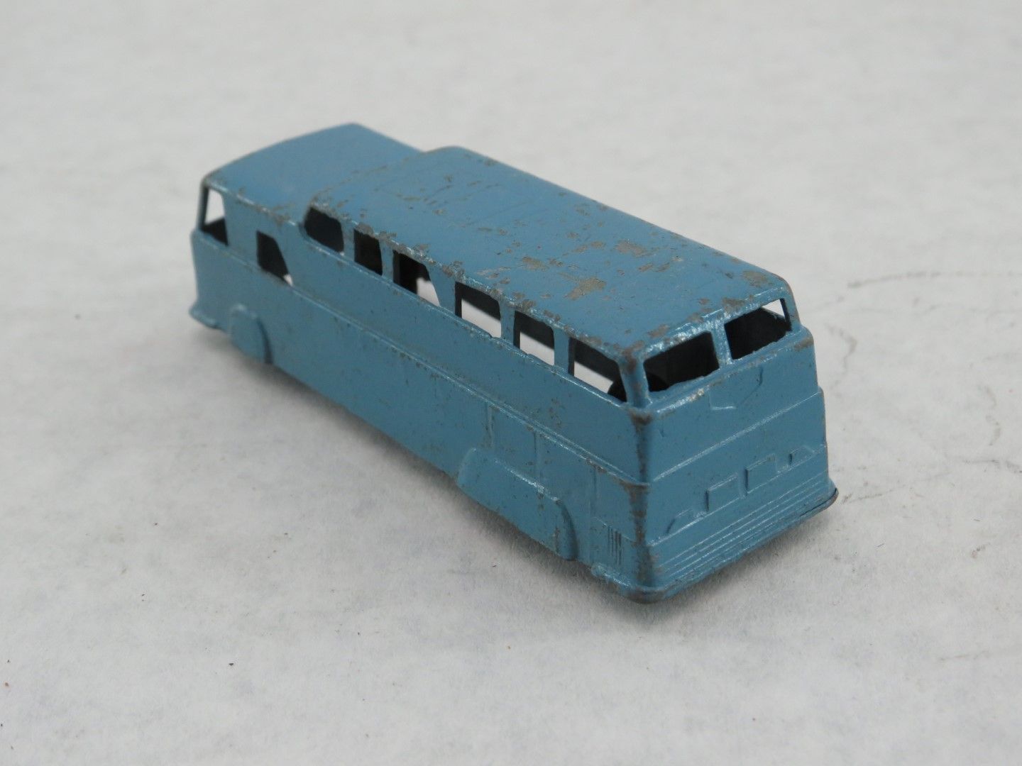 Blue die-cast toy bus with visible windows. Antique.