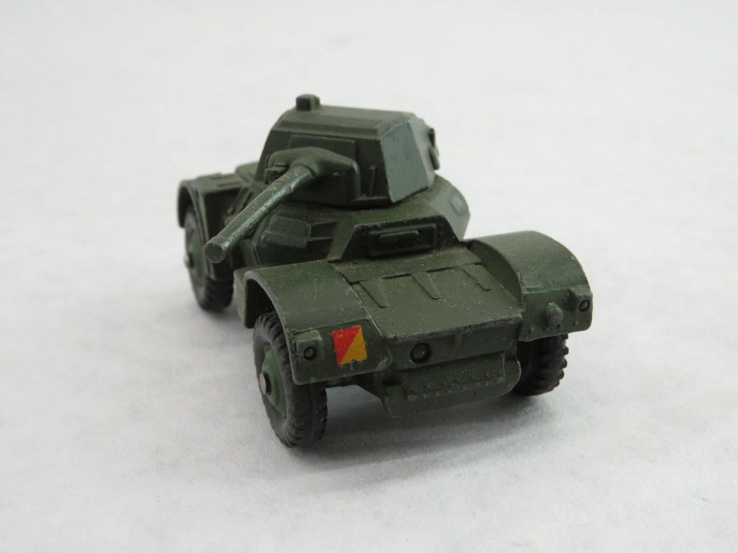 Green toy armored car with a turret on a white background. Antique.