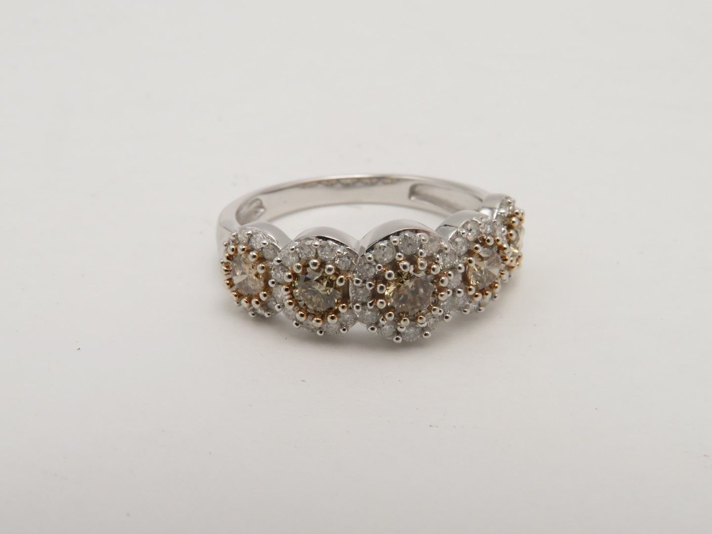 Diamond ring with five clusters of brown and white stones on a silver band.