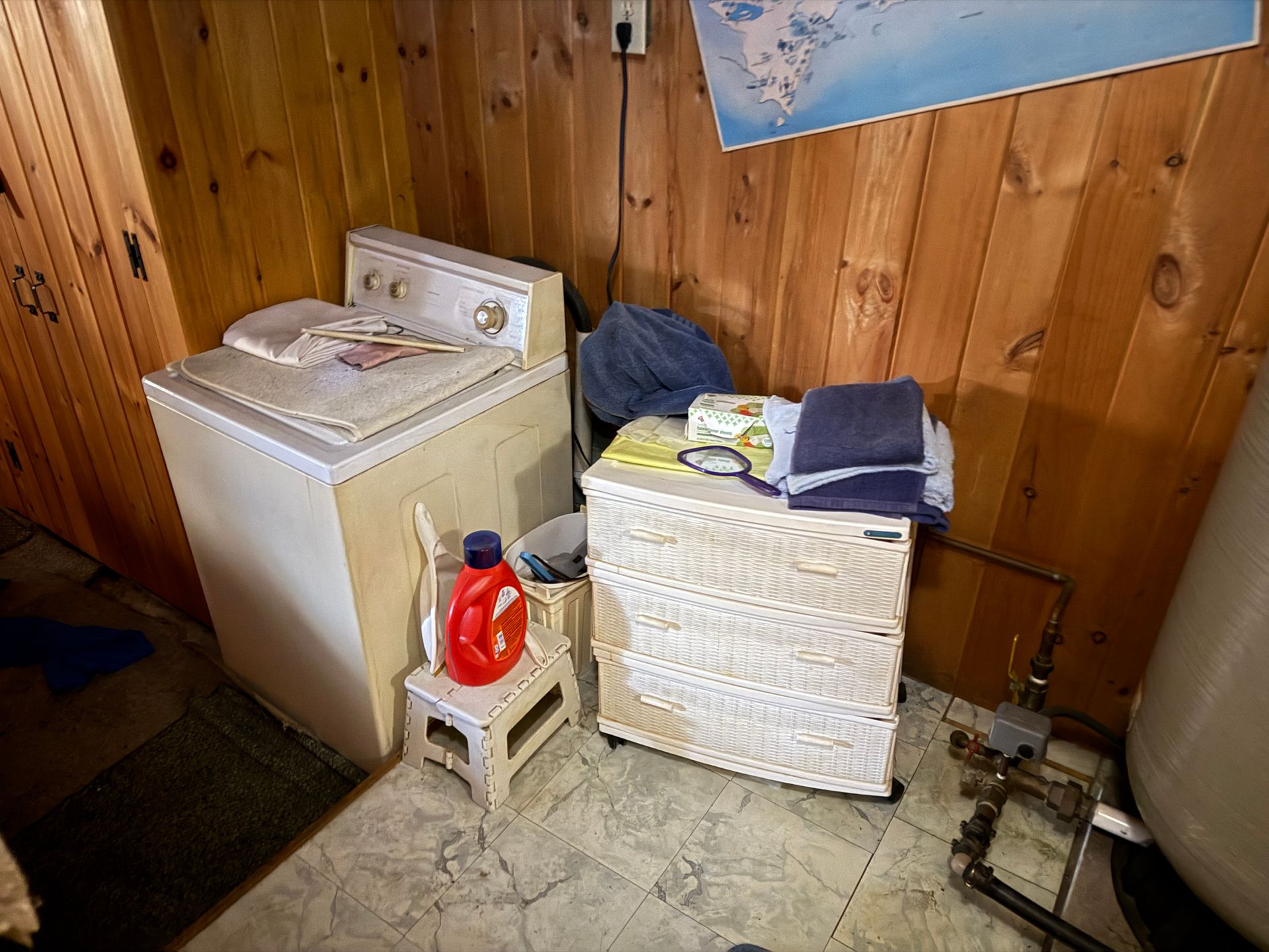 Laundry room with a washing machine, storage unit.