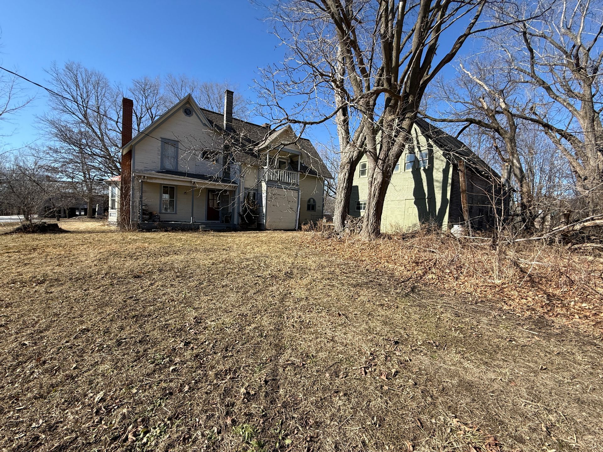 Two-story house with a wooden barn next to it.