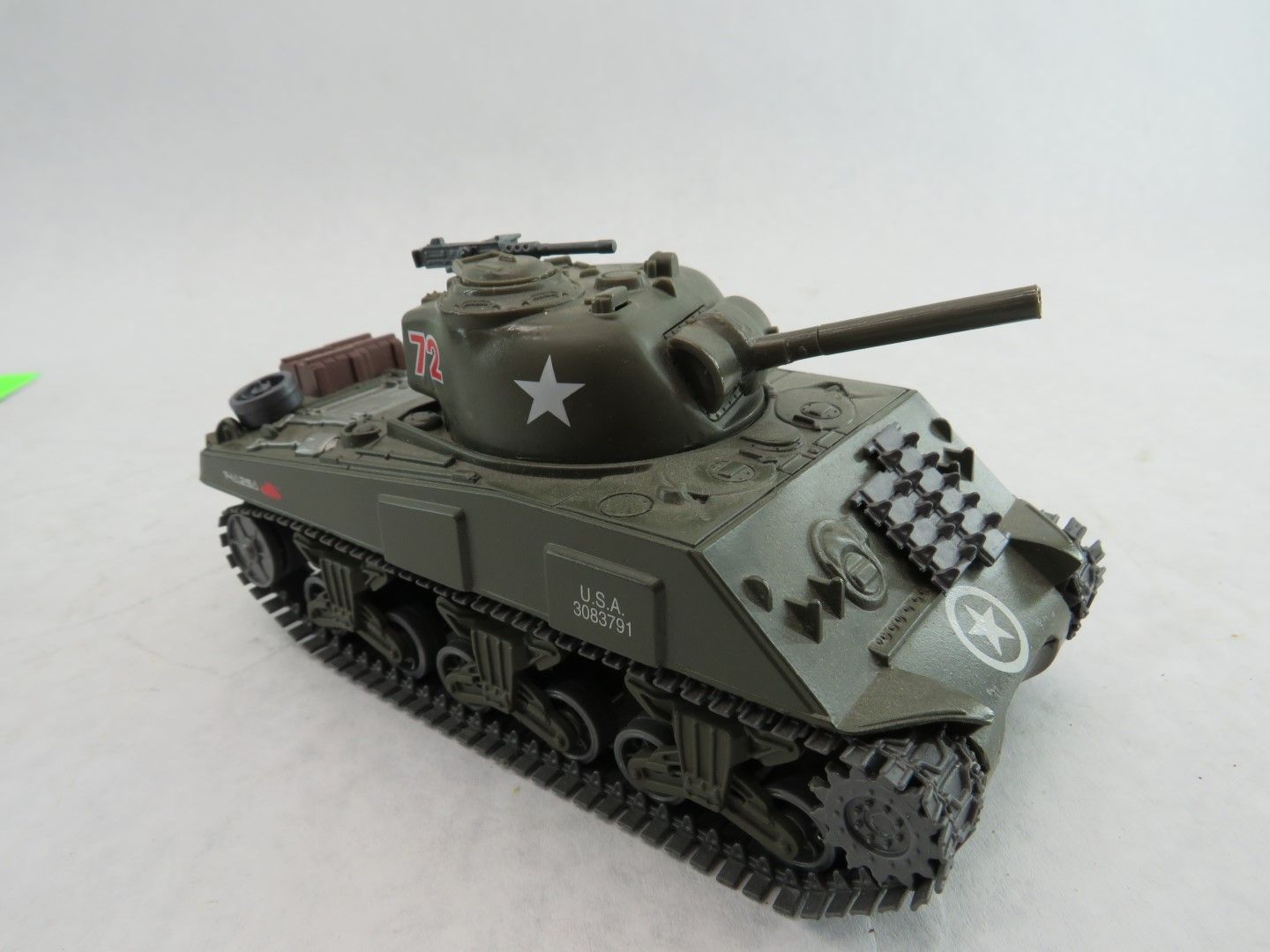 Toy Sherman tank, green with markings, white star and checkerboard pattern.