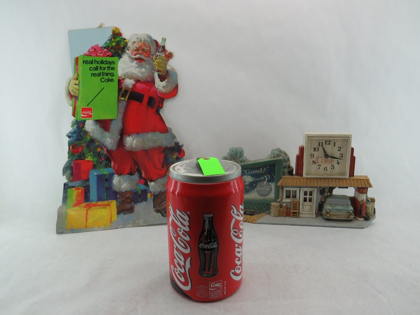 Coca-Cola can with a Santa Claus sign and a vintage gas station clock.