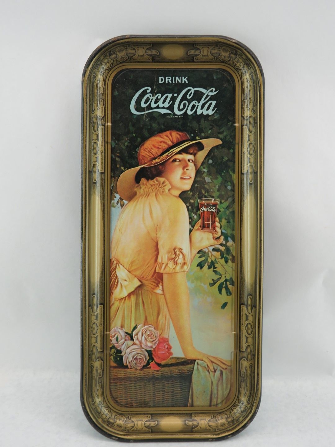 Coca-Cola serving tray with woman in a hat, holding a glass of Coca-Cola, with roses in basket.