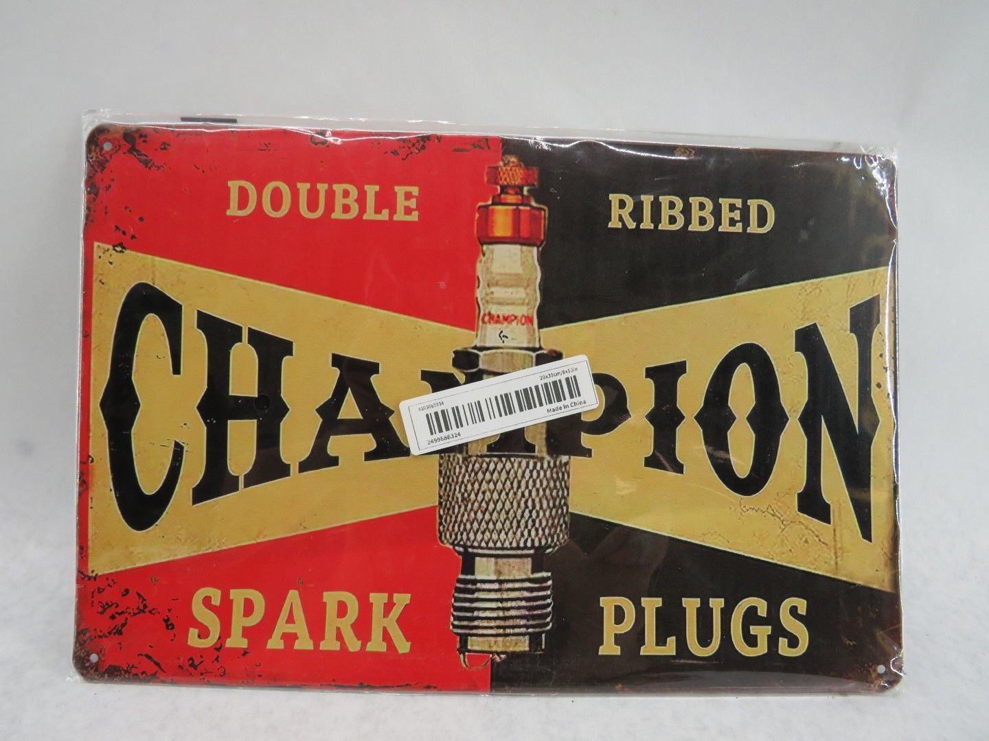 Vintage Champion spark plugs metal sign, red and black background with gold text and spark plug illustration.