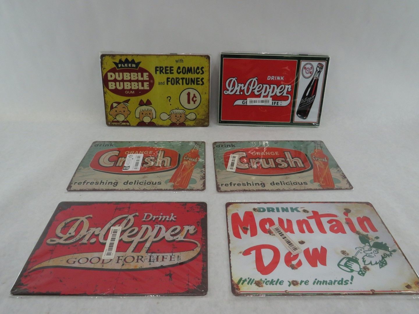 Collection of vintage metal signs advertising Bubble Bubble gum, Dr. Pepper, Crush, and Mountain Dew.