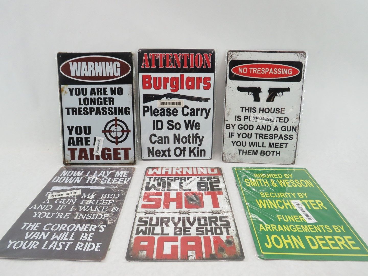 Collection of weathered metal warning signs with aggressive messages.