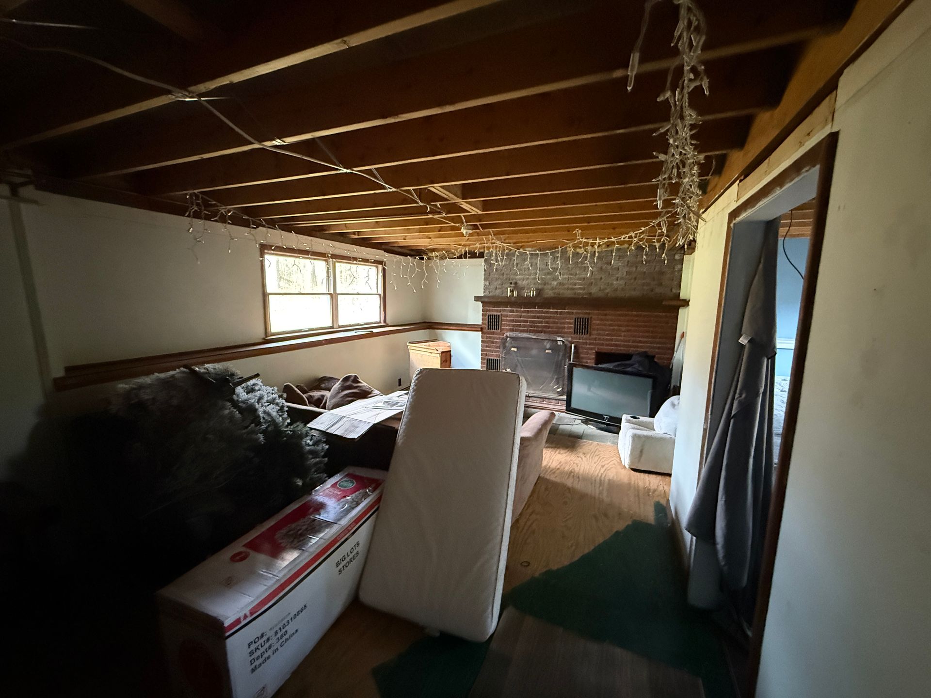Room interior with exposed ceiling beams, fireplace.