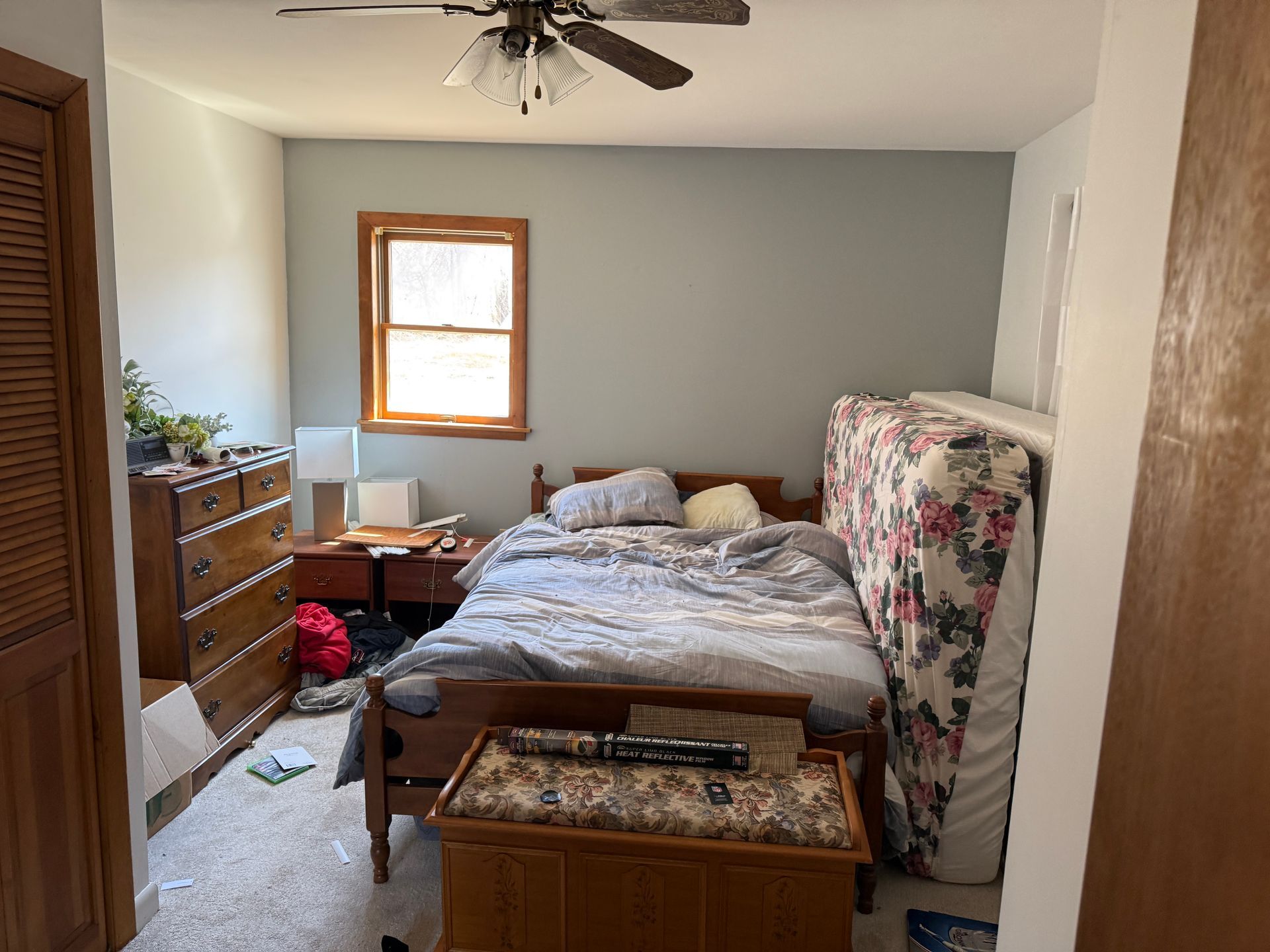 Bedroom with bed, dresser, window, and a ceiling fan.