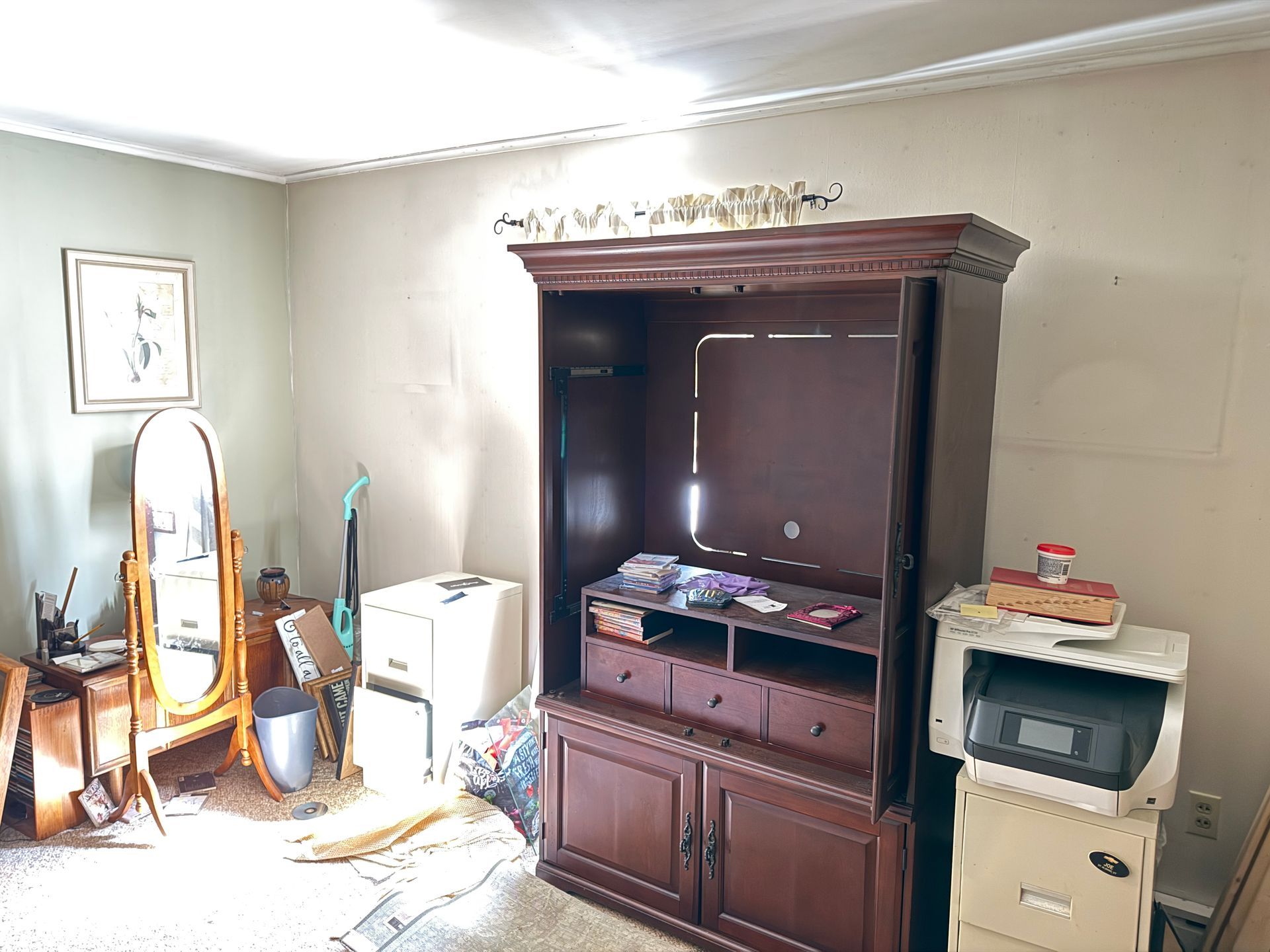 Room with a dark wood entertainment center, mirror.