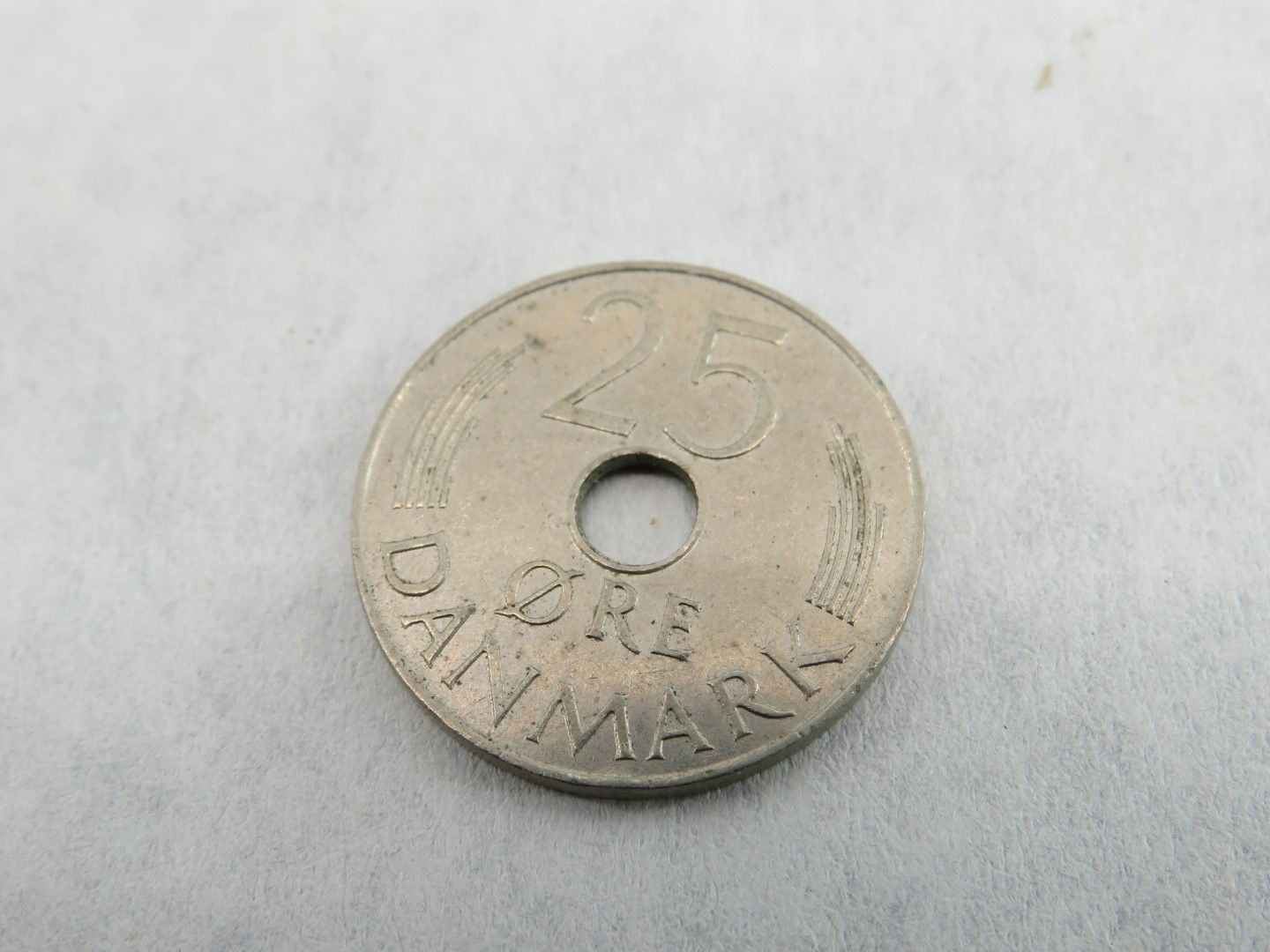 Danish 25 Øre coin with a hole in the center, showing the number 