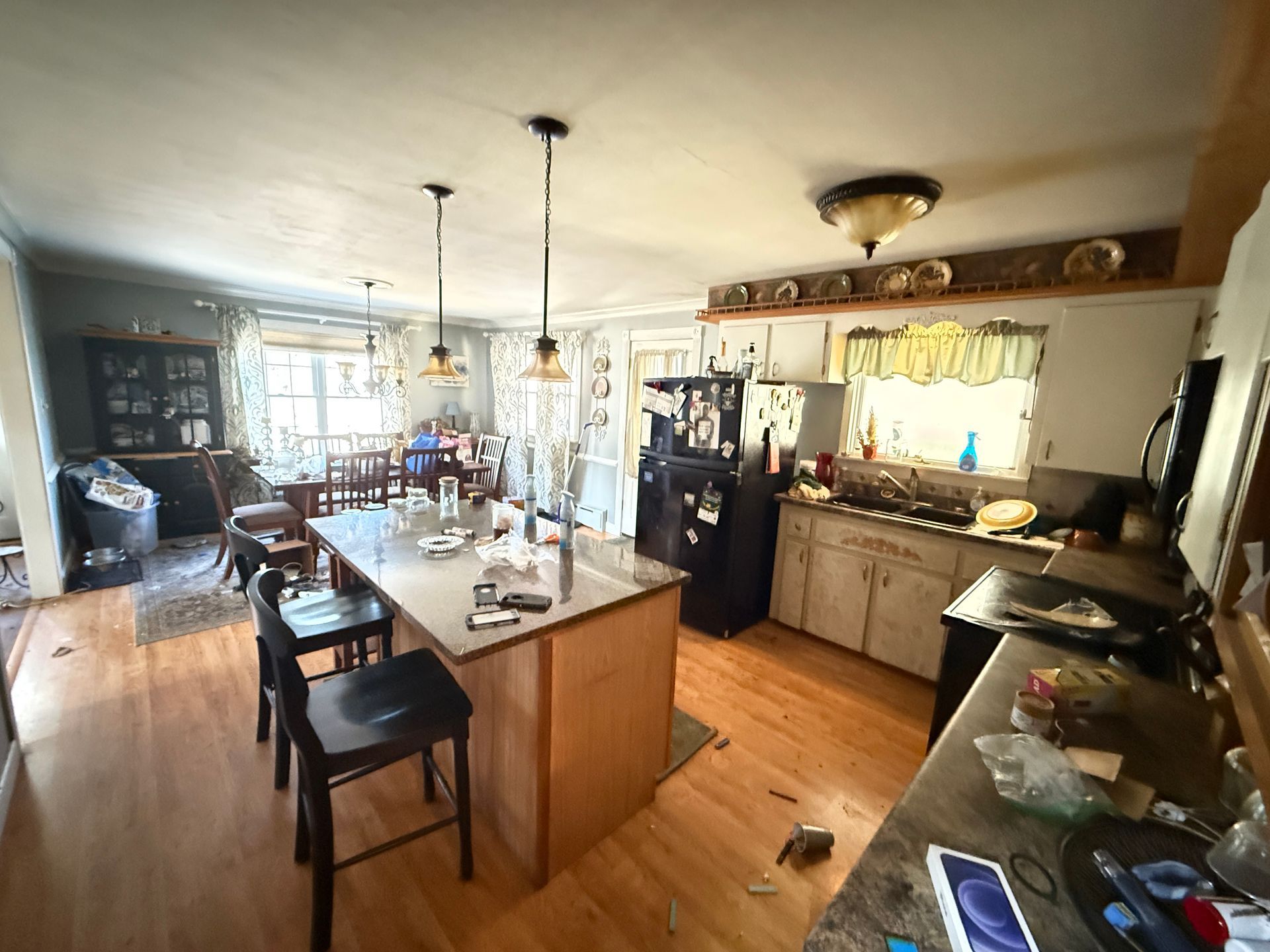 Kitchen with an island, cabinets, a fridge, and a dining table.