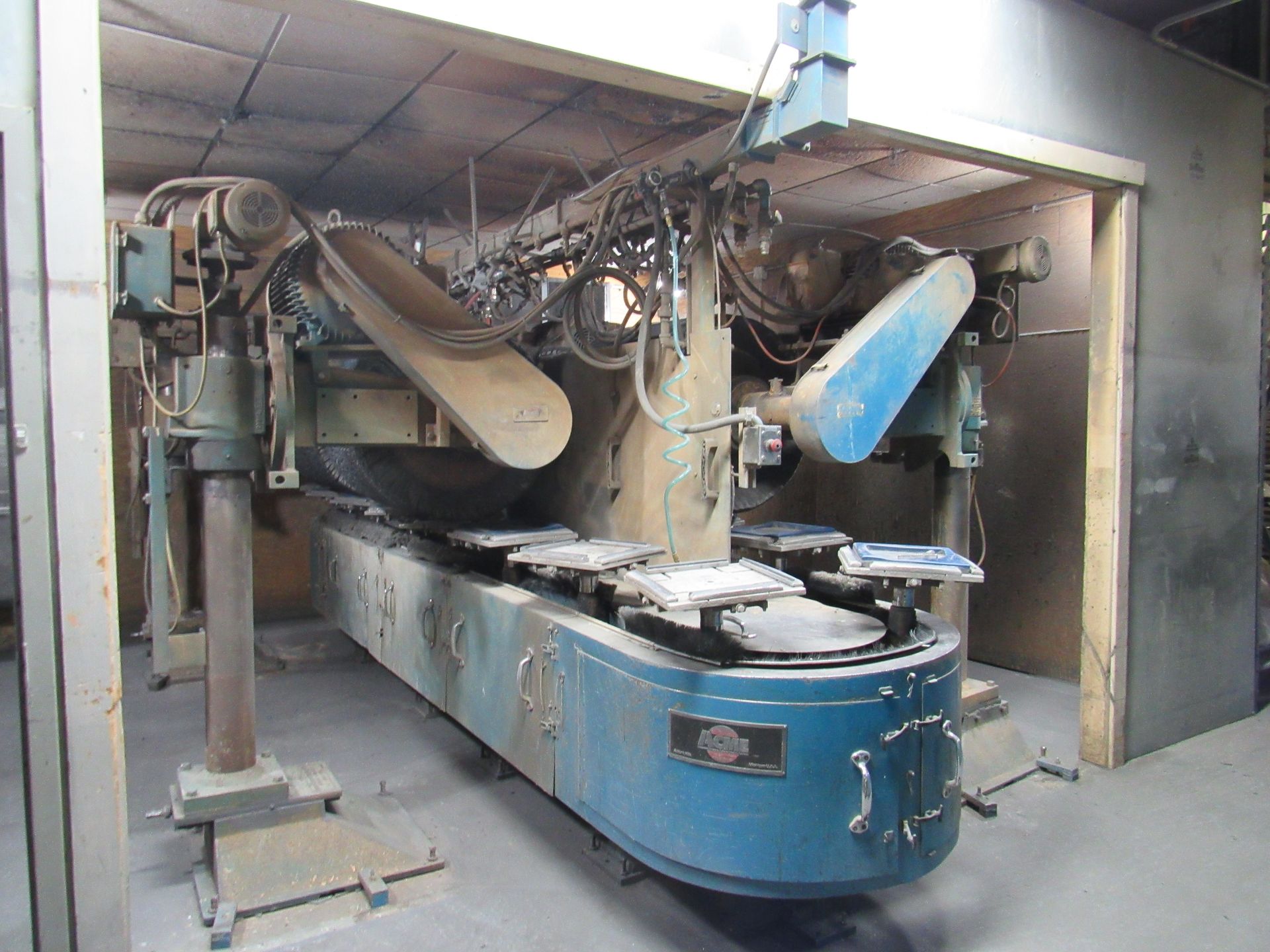 Large blue industrial machine with conveyor belt, housed in a rectangular enclosure.