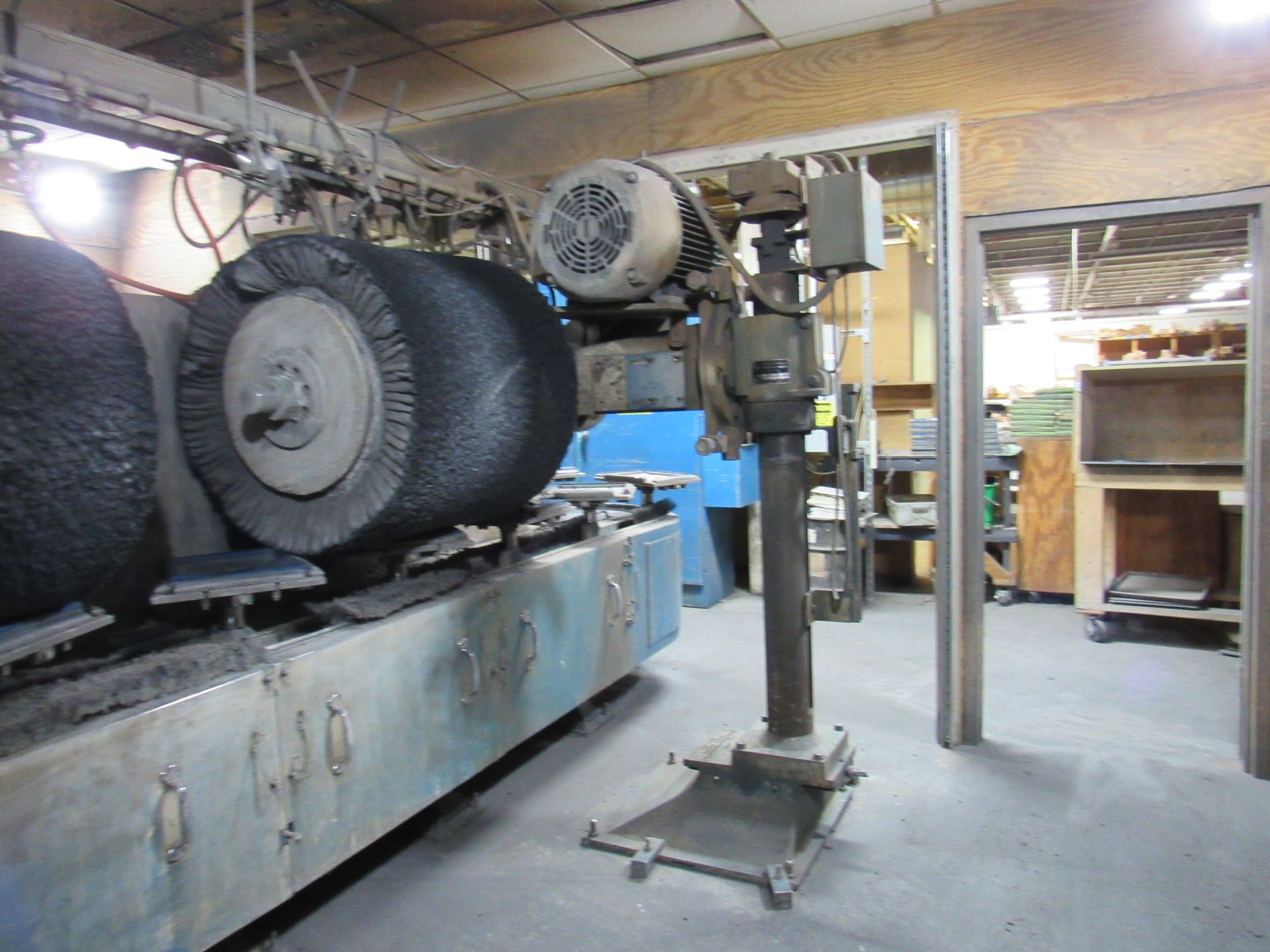 Large industrial brush machine in a workshop.