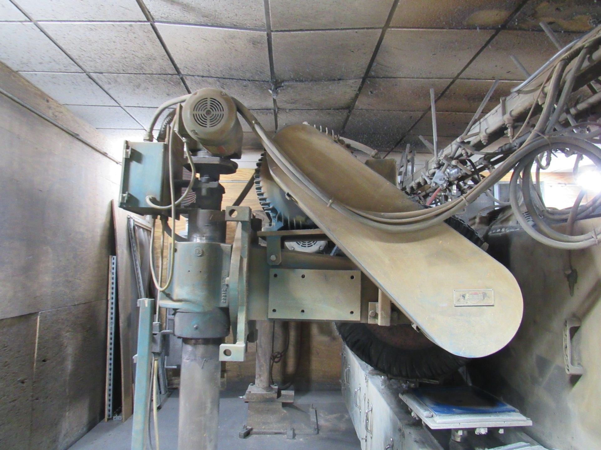 Industrial machinery with motor and belt, positioned in a workshop setting.