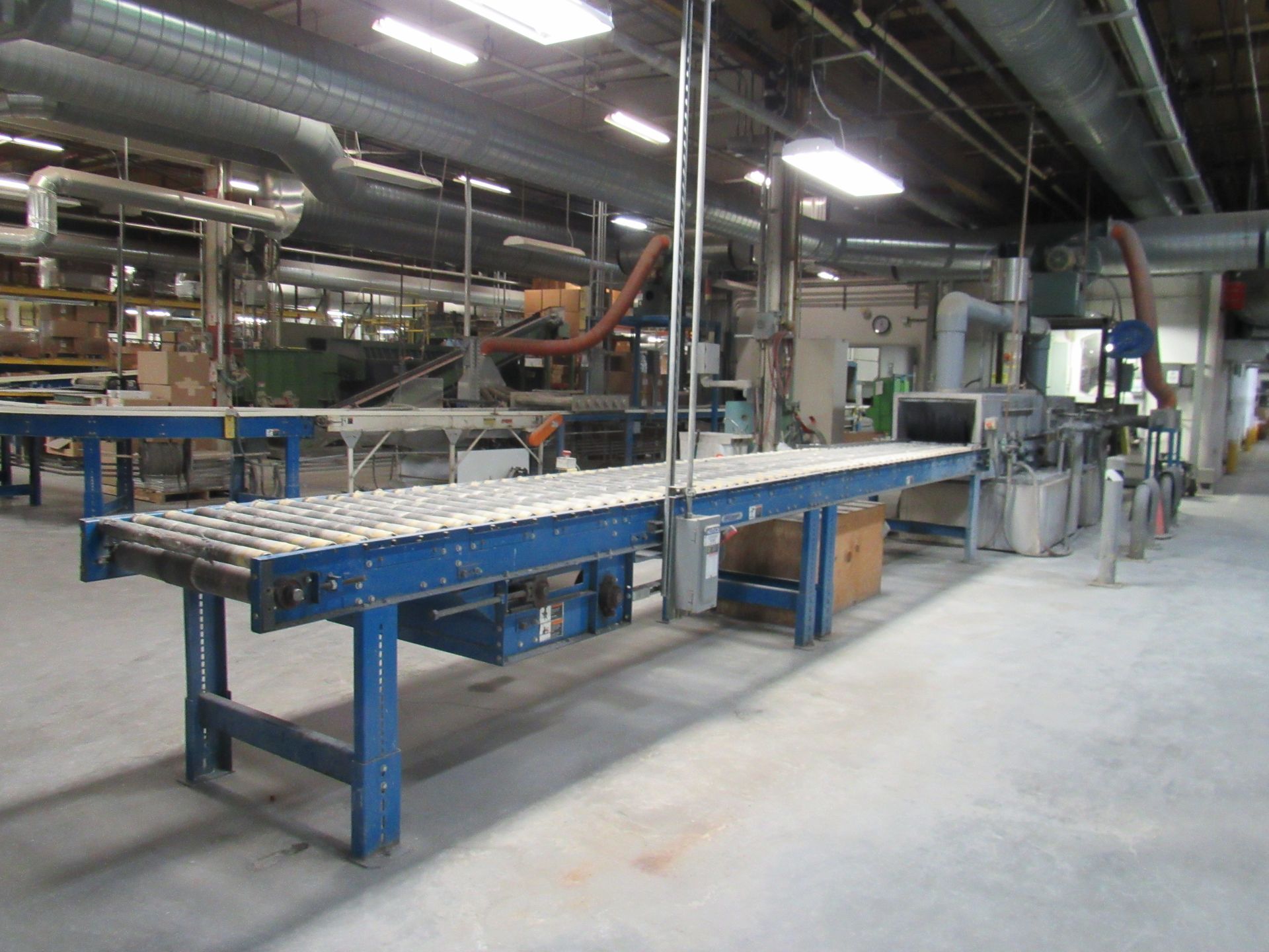 Blue conveyor belt in a factory setting.