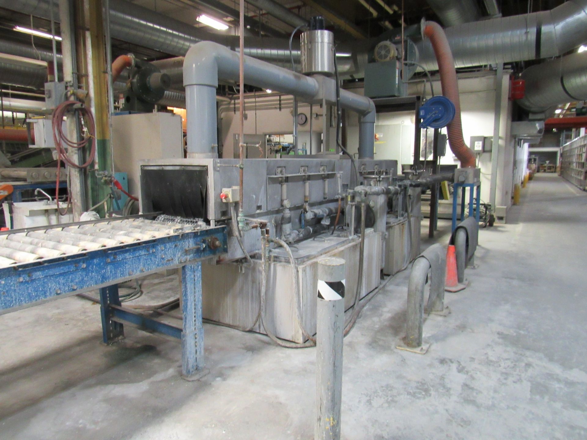 Industrial machine with conveyor belt, pipes, and ventilation in a factory setting.