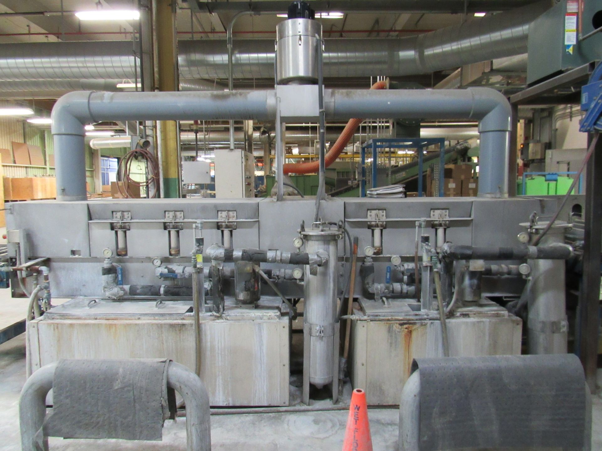 Industrial machinery with pipes and tanks in a factory setting.