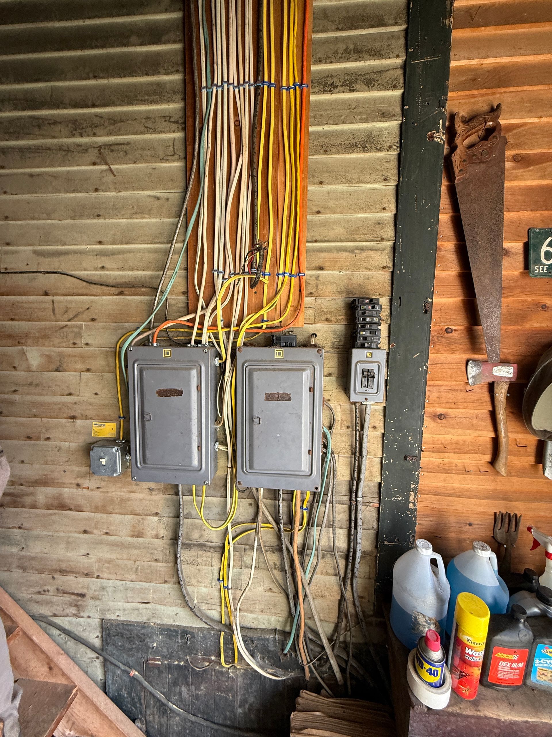 Electrical panel and wiring on wood siding.