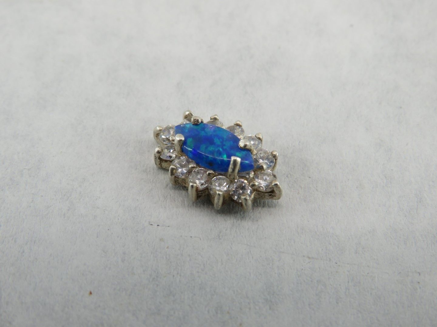 Blue opal and clear gemstone pendant on a white surface.