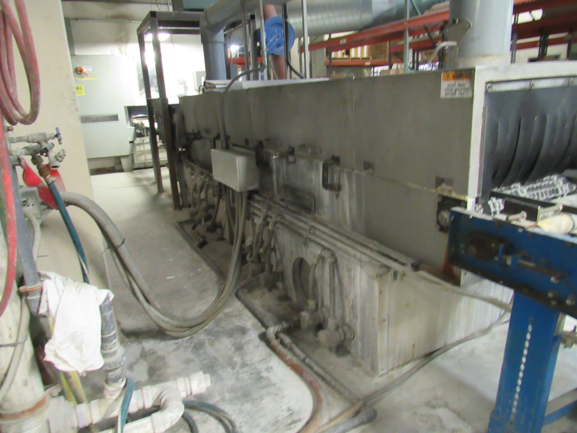 Industrial machinery in a workshop setting, with pipes and electrical components visible.