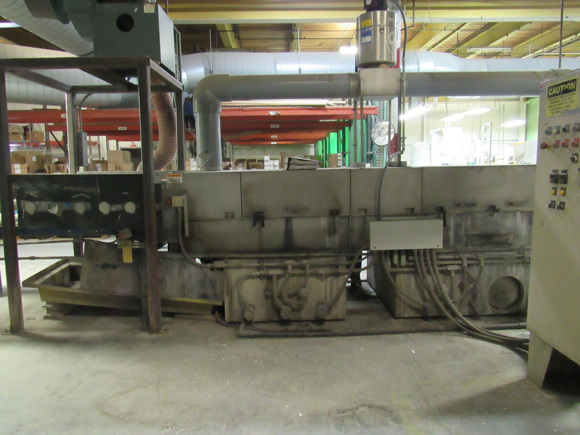 Industrial furnace with ductwork and control panel in a factory setting.
