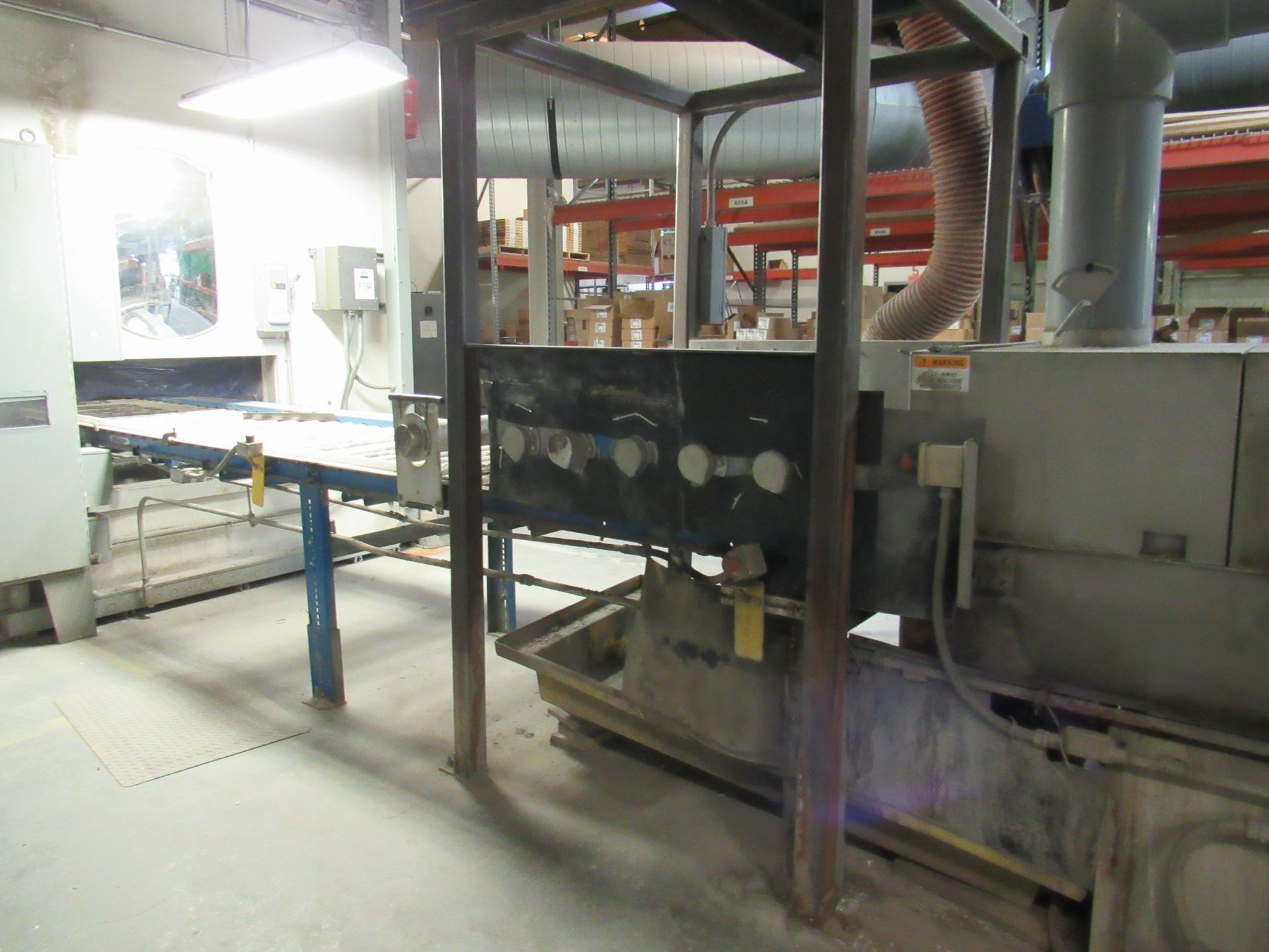 Industrial machinery in a workshop, including a rectangular ventilation system and a large machine.