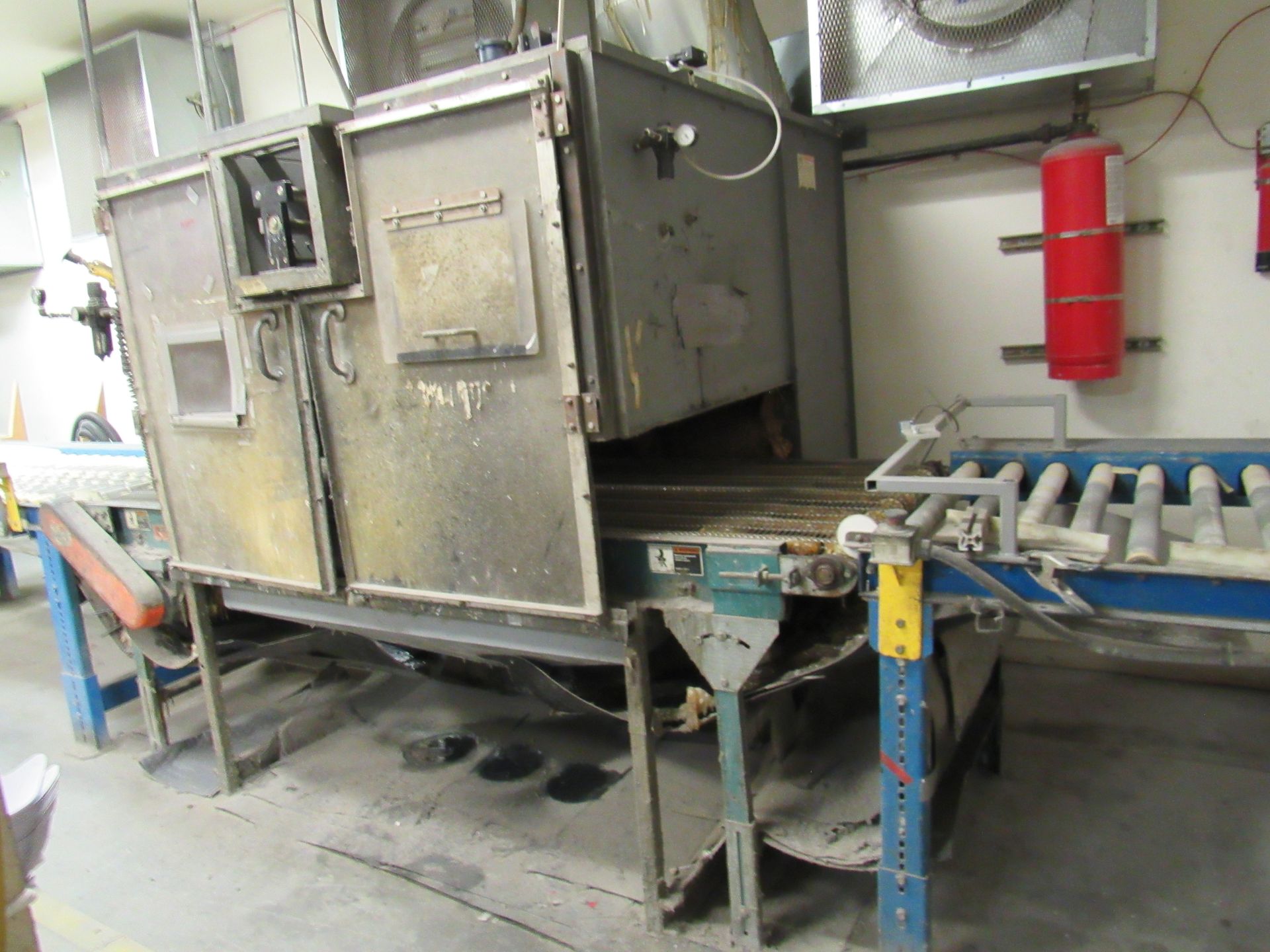 Large industrial machine with conveyor belts in a workshop setting.