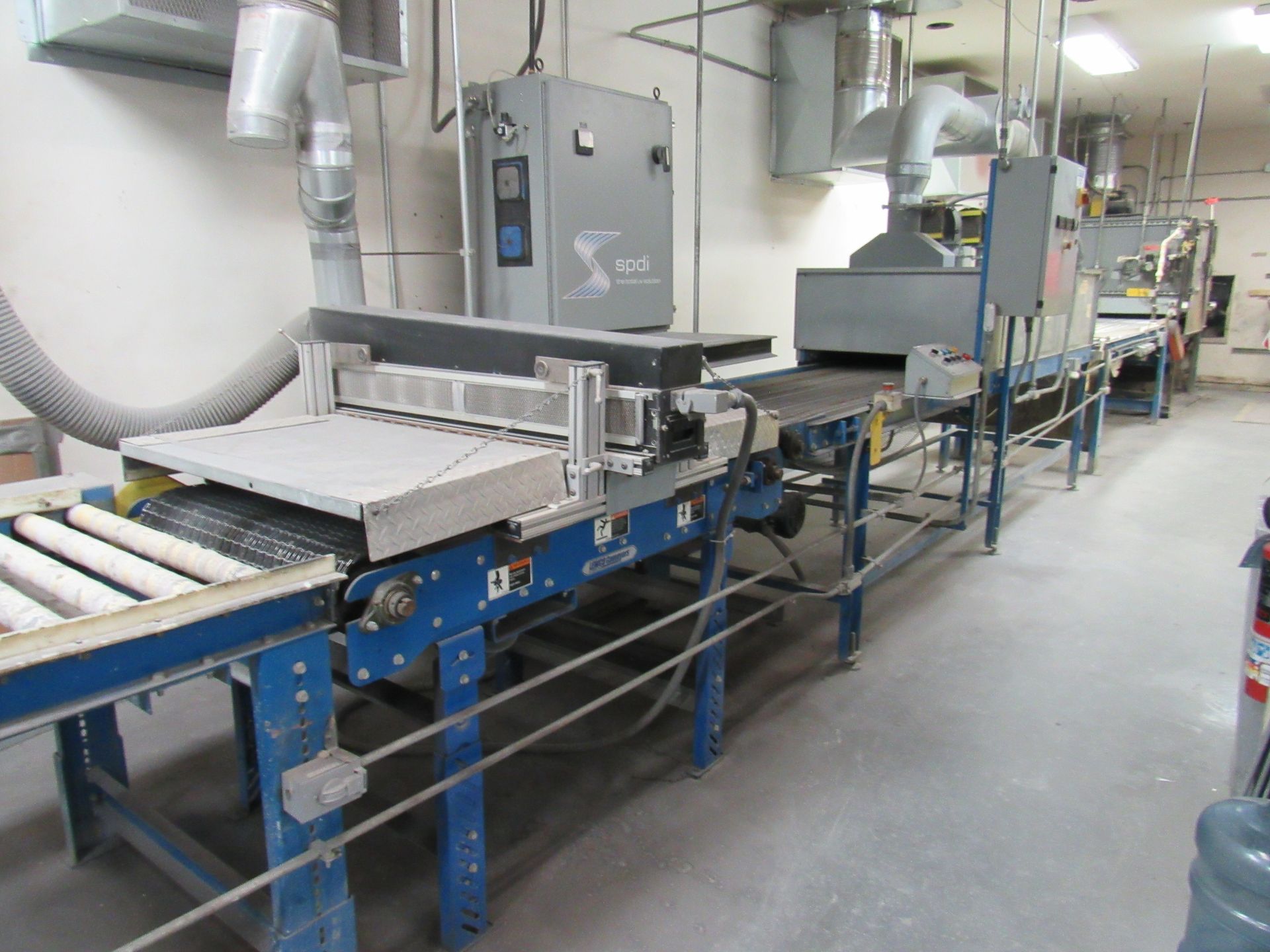 Industrial conveyor belt system with metallic components in a factory setting.