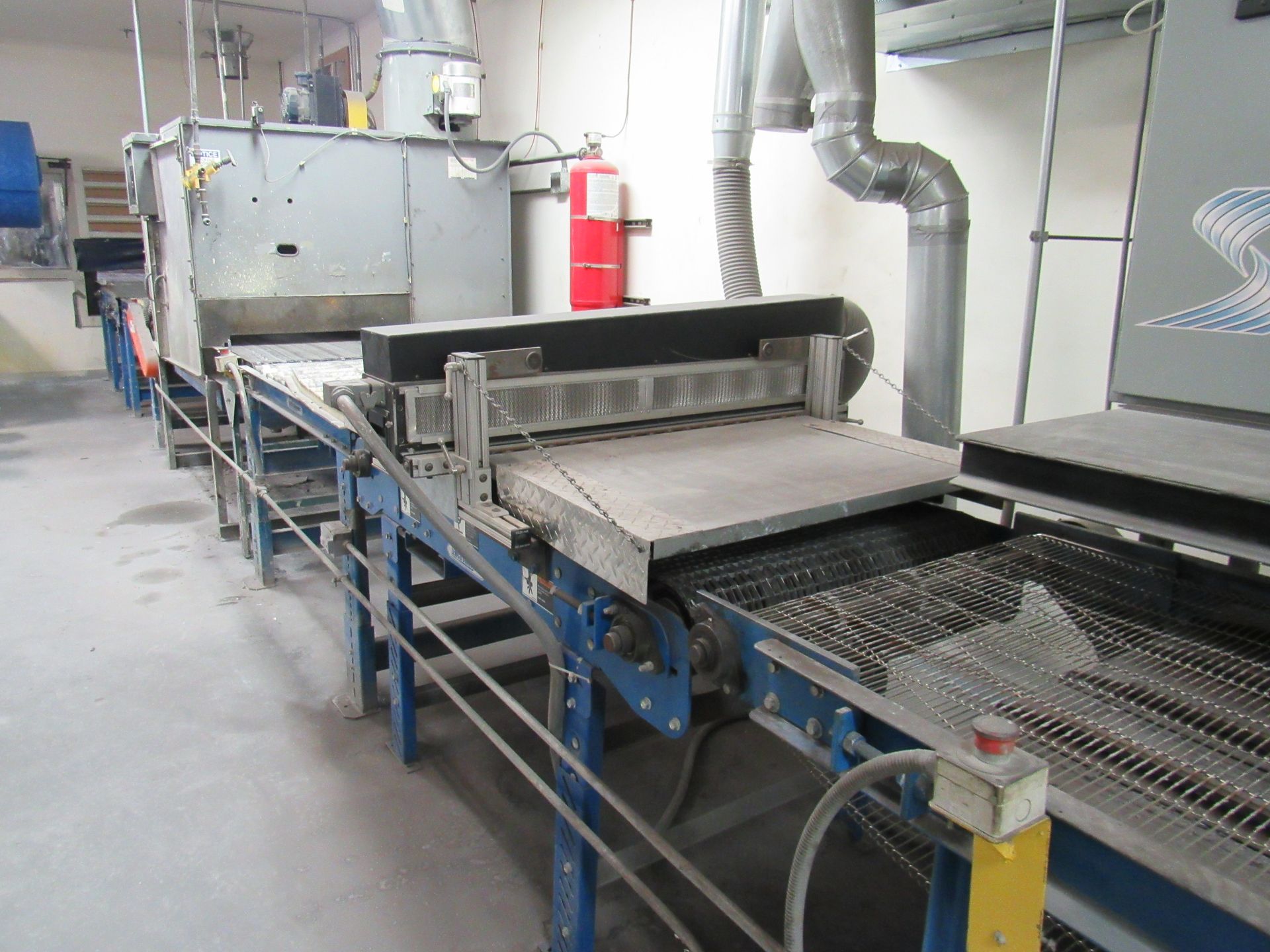 Industrial conveyor system with machinery in a factory setting.