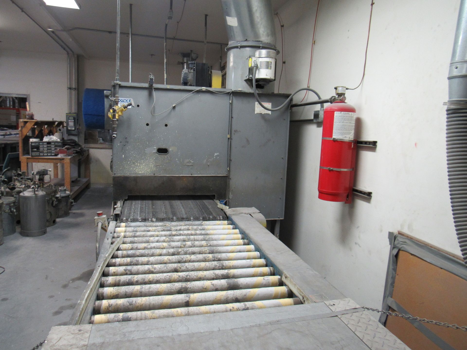 Conveyor belt leading into a gray industrial machine.