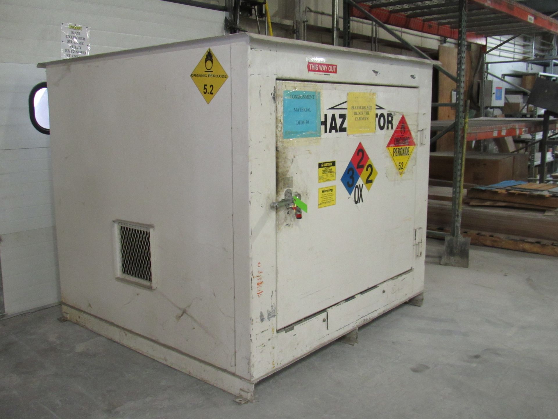 White HAZMAT storage cabinet with warning labels in an industrial setting.