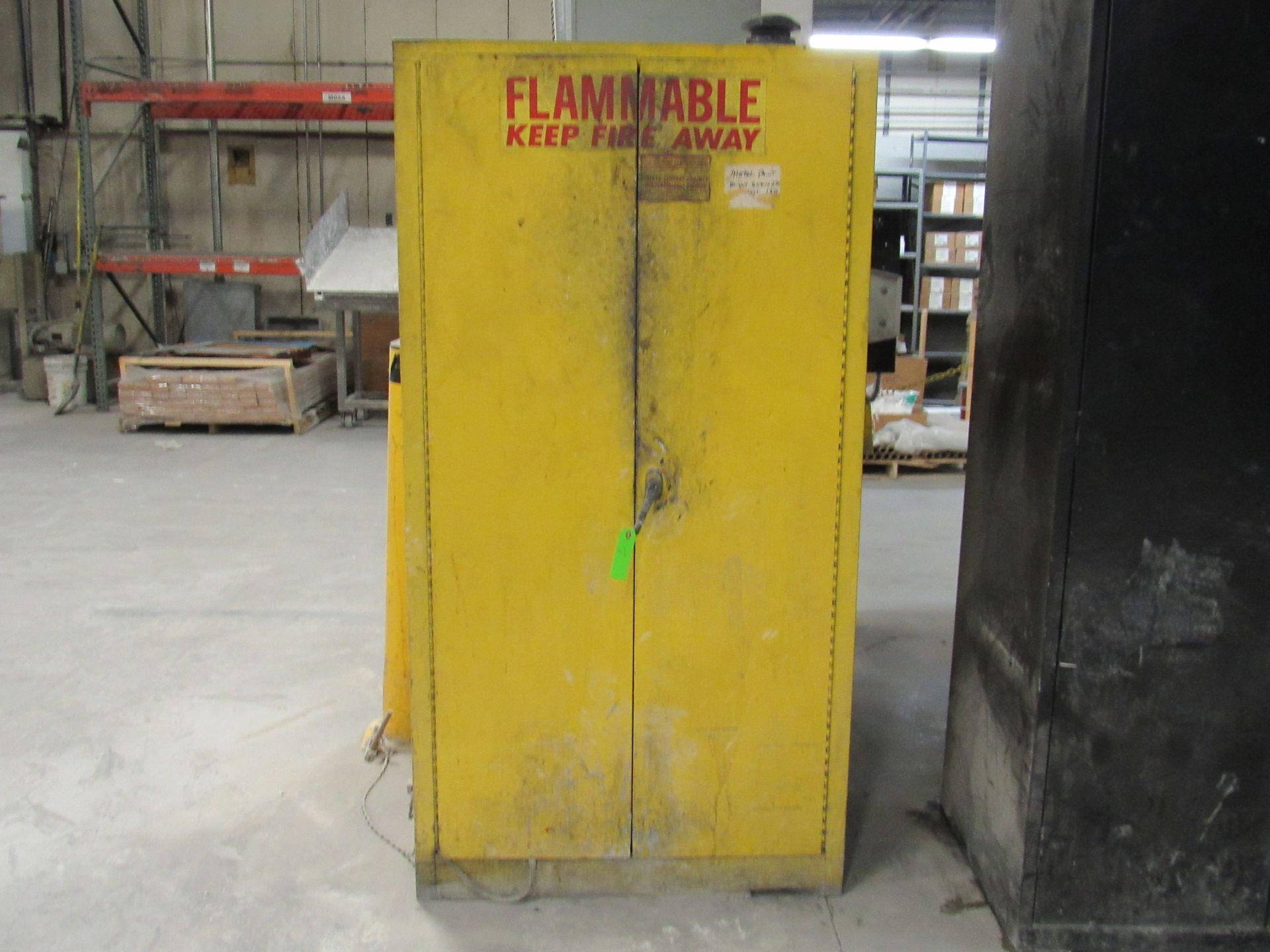 Yellow flammable liquid storage cabinet in a warehouse.