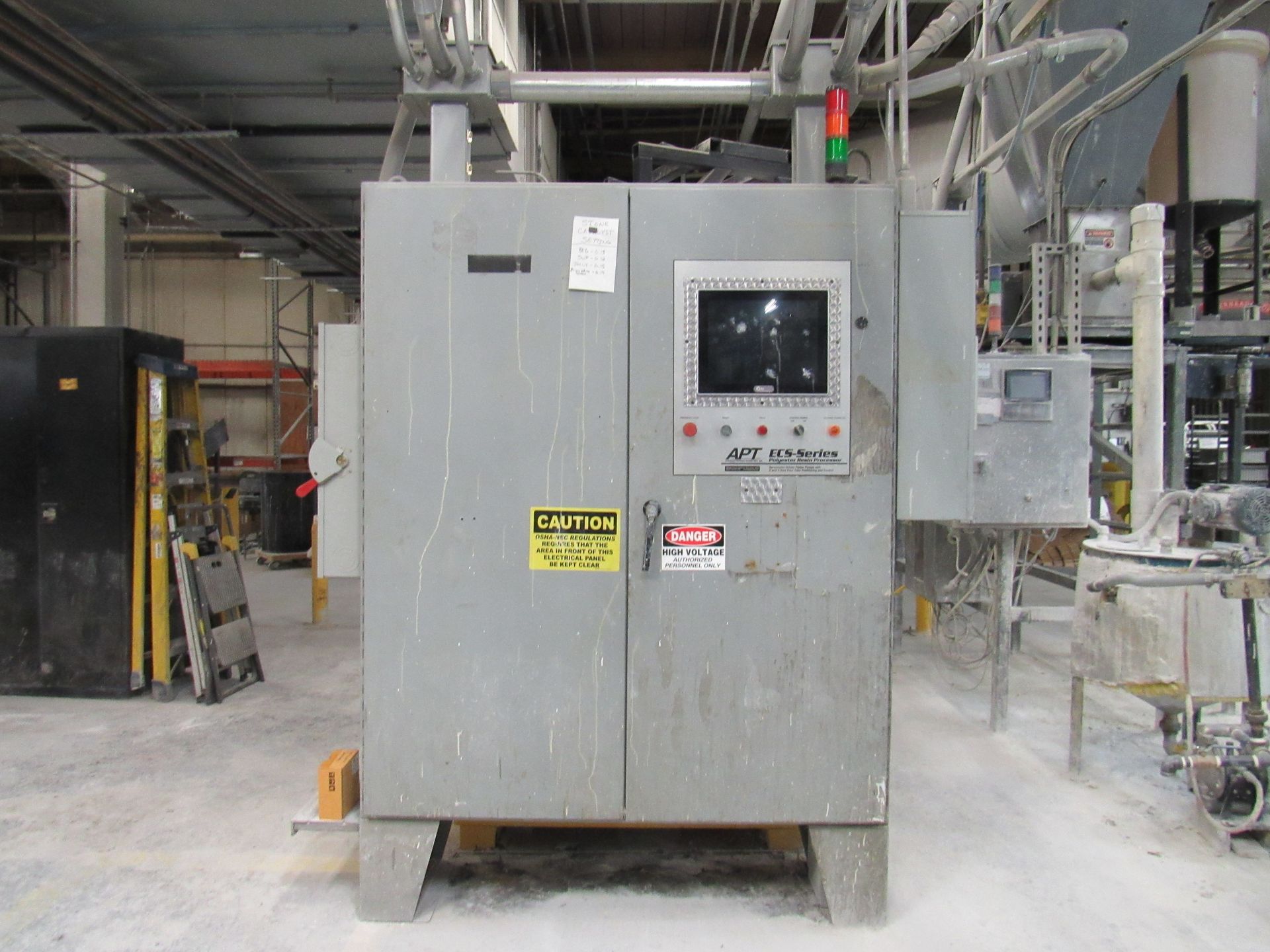 Gray industrial control panel in a factory setting.
