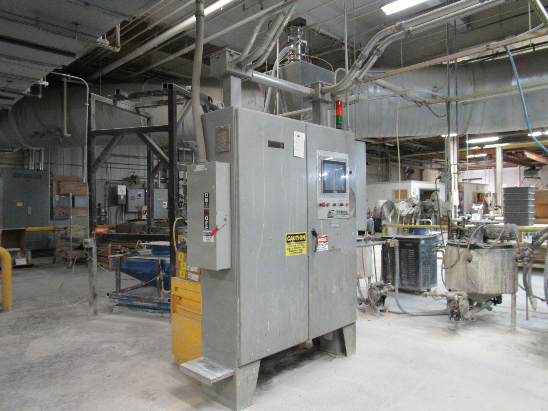 Industrial control panel in a factory setting with surrounding machinery and equipment.