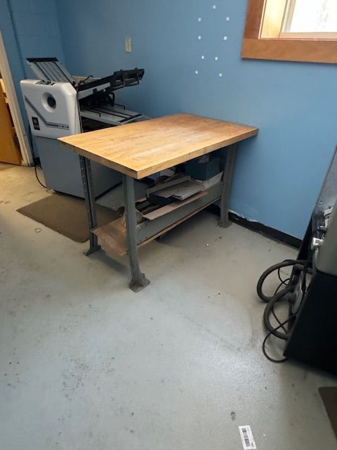 Wooden work table with a metal frame in a room.
