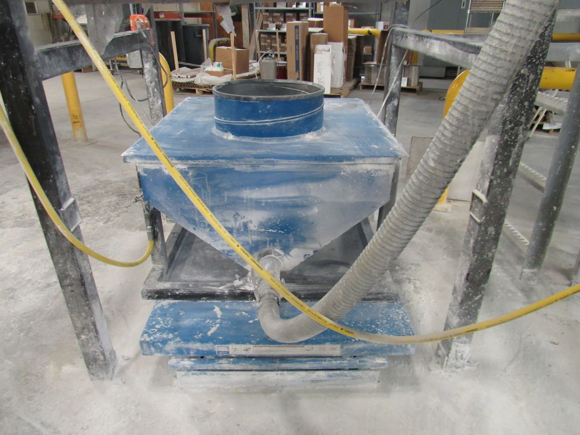 Blue industrial dust collector with a hose.