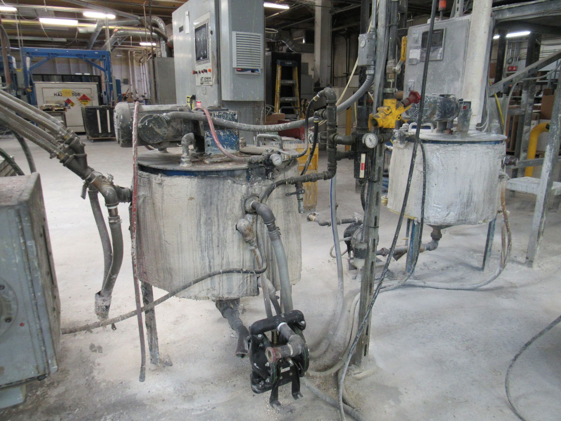 Industrial tanks with pipes and equipment in a factory setting.