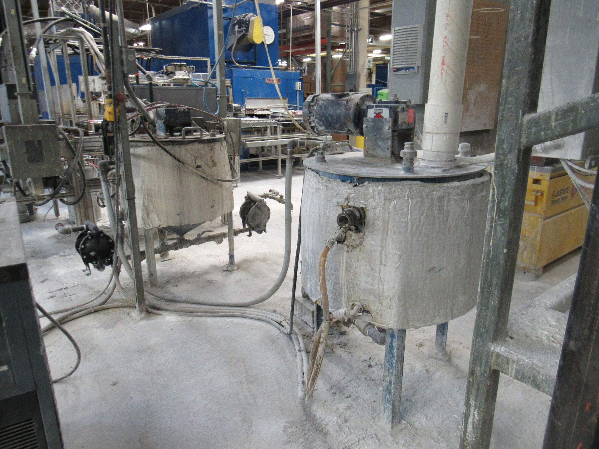Industrial tanks with pipes and wires in a factory setting.
