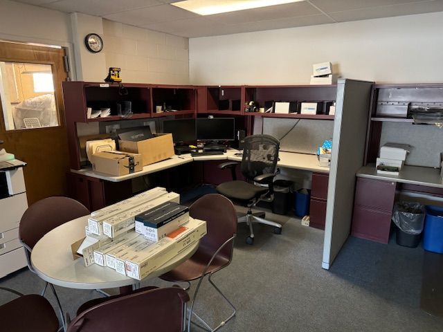 Office with desk, computer, printer, and round table with chairs.